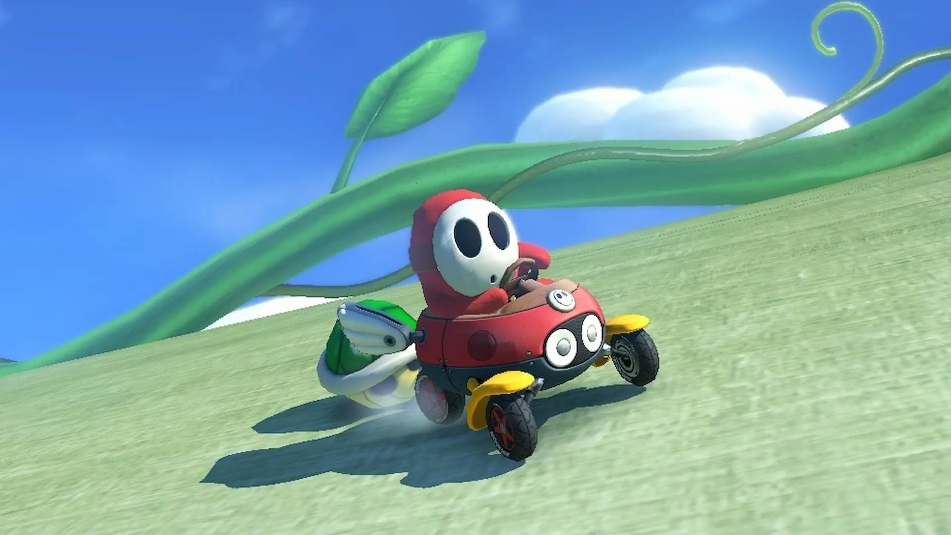 Red Shy Guy bị rượt đuổi bởi mai rùa xanh trong một cuộc đua Mario Kart 8 Deluxe đầy kịch tính